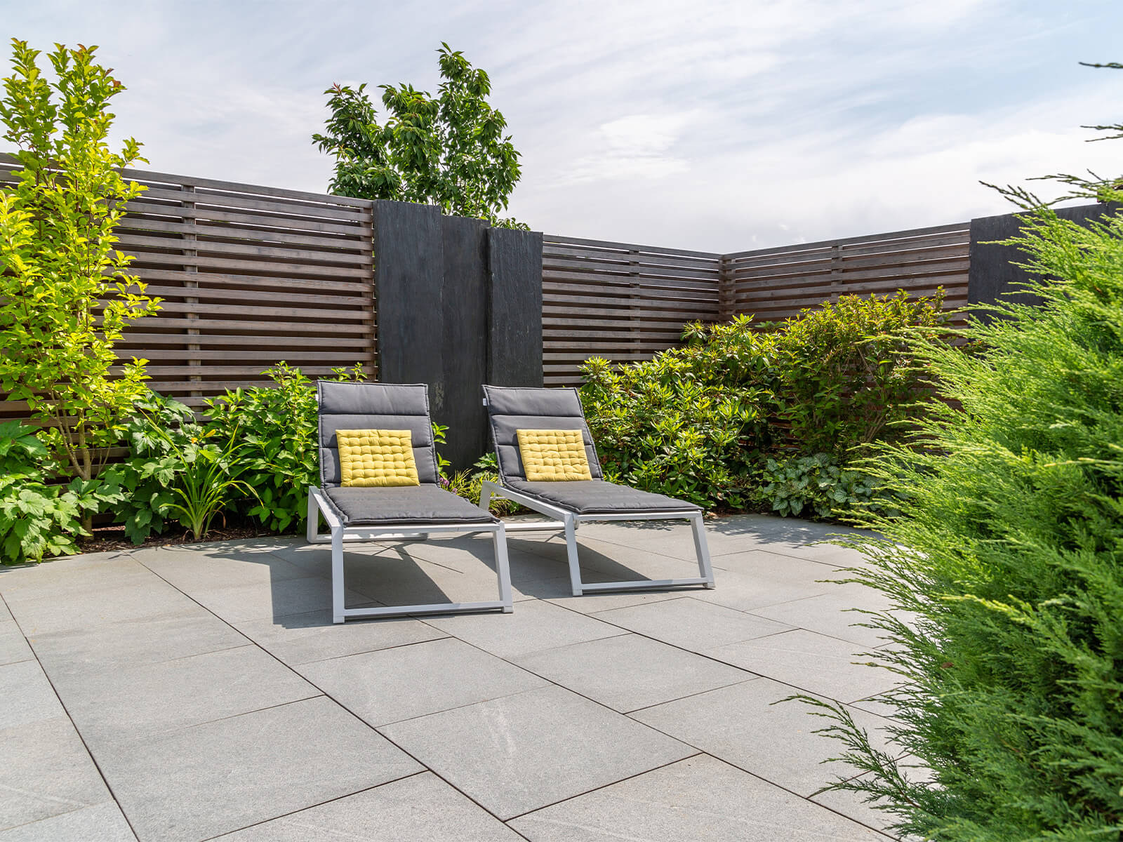 Blick auf zwei Liegen in der Sonne auf einer schicken Terrasse