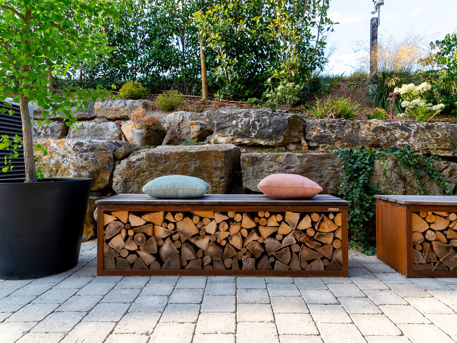 Nahaufnahme einer Bank in welcher Holzscheite gelagert werden können