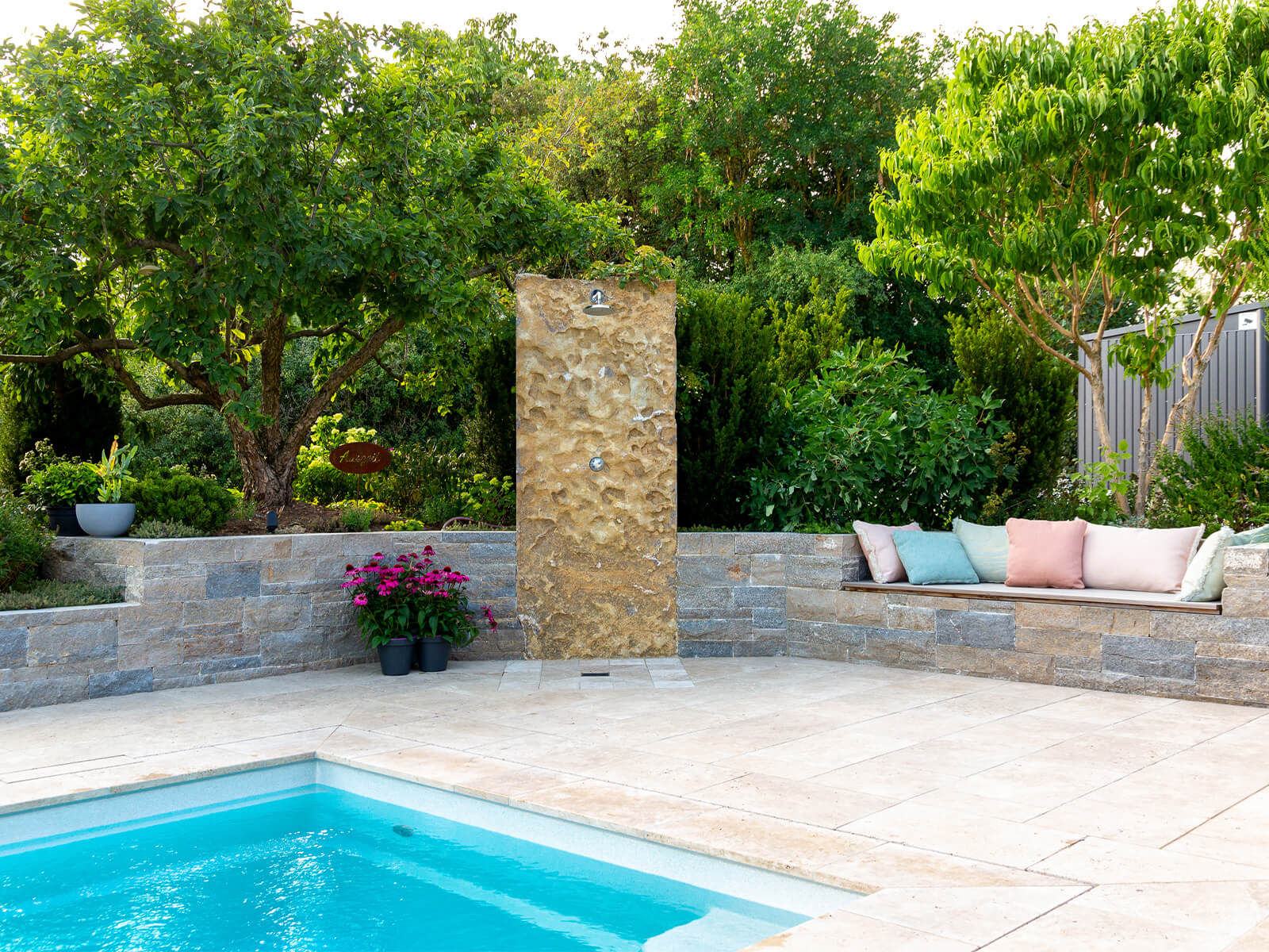 Blick auf grüne Bäume neben einem Pool mit Outdoor Dusche